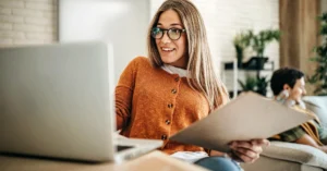 Kundin, die einen Laptop und Dokumente für den Online-Selbstservice nutzt